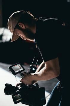 a man holding a camera in his hand and looking at the screen on top of it