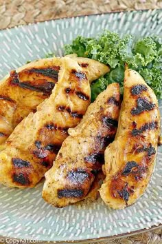 grilled chicken and broccoli on a glass plate with a woven tablecloth