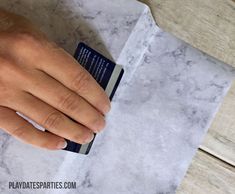 a person's hand on top of a piece of paper with a book in it