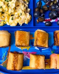 there is a blue tray with food on it that includes sandwiches, macaroni and cheese