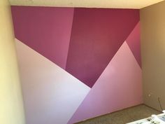 an empty room with pink and purple walls painted on the wall, in front of a window