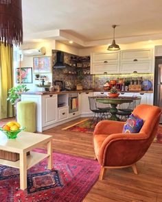 a living room filled with furniture next to a kitchen