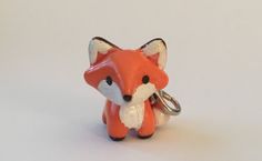 a red fox keychain is shown on a white surface