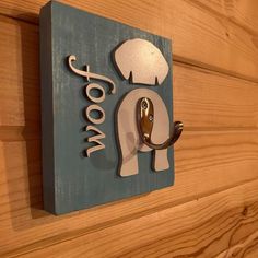 a wooden sign with an elephant and mushrooms on it's head is mounted to the side of a wood paneled wall