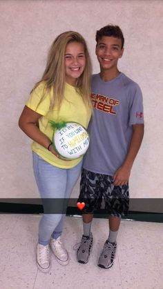 a boy and girl standing next to each other holding a frisbee in their hands