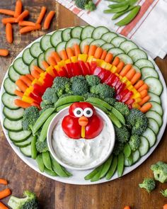 a platter filled with veggies, dip and a turkey face on it