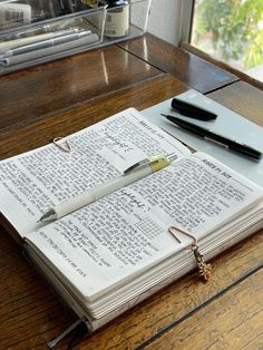 an open notebook with a pen sitting on top of it next to a cell phone