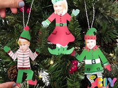 handmade christmas ornaments hanging from a tree in front of someone's fingernail