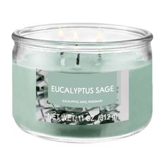 a candle that is sitting in a glass jar with the label eucalyptusplus sage on it