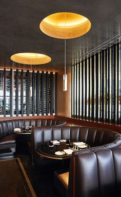 a restaurant with round tables and leather booths