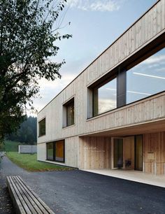 the building is made out of wood and has large windows on each side, along with wooden benches