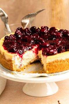 a cheesecake with berry topping on a cake plate