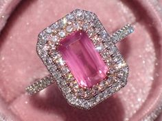 "A beautiful and elegant engagement ring featuring a one-of-a-kind glowing radiant-cut untreated pink sapphire in white and rose gold diamond double halo. The center stone is a beautiful and rare radiant-cut sapphire, that weighs 1.51 carats and measures 8.1x4.9mm. It has a beautiful pink color and microscopic \"silk\" gives it a velvety glow! This sapphire is completely untreated and comes from Tunduru, Tanzania. An excellent choice for a one-of-a-kind engagement ring! The sapphire is set in a Pink Sapphire And Diamond Engagement Ring, Colorful Vintage Engagement Rings, Pink And Gold Engagement Ring, Hot Pink Engagement Ring, Barbie Engagement Ring, Pink Diamond Engagement Ring Vintage, Pink Diamond Ring Engagement, Engagement Rings Pink, Pink Sapphire Wedding Ring