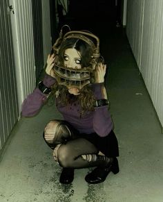 a woman kneeling down with a mask on her head