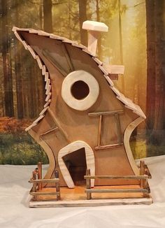 a sculpture made out of wood in the shape of a house with an eye on it