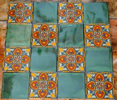 an artistic tile design on the floor in a room with orange and blue tiles,