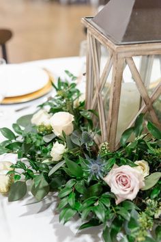 the centerpieces on this table are made out of wood and greenery