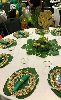 a table set with plates and place settings for an event or party, surrounded by balloons