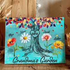 a wooden sign with flowers and a tree painted on it