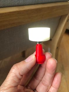 a person holding a small red object with a light on it's tip in their hand