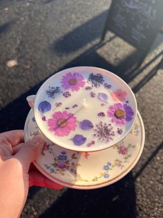 a person holding a plate with flowers on it