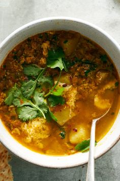 a white bowl filled with meat and vegetable soup