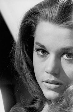 an old black and white photo of a woman with her hair blowing in the wind