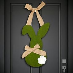 a green door hanger with a white flower and a bunny's head on it