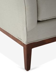 a close up view of the back end of a couch with wood legs and armrests