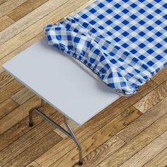 a blue and white checkered table cloth sitting on top of a wooden floor