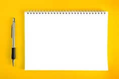 a notepad with a pen next to it on a yellow background