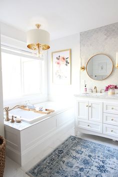 a bathroom with a tub, sink and large mirror in the corner by the window