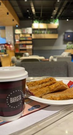 a cup of coffee next to some food on a table in a store or restaurant