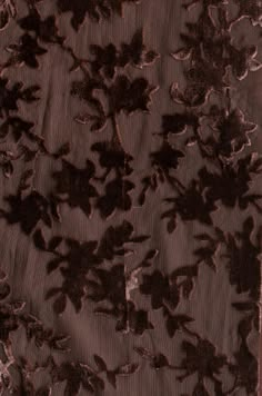 an image of a piece of fabric with flowers and leaves in brown color on black background