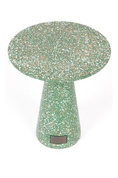 a green and white cake stand with sprinkles on it's surface