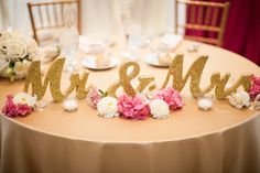 the table is decorated with flowers and mr and mrs signs on it's side