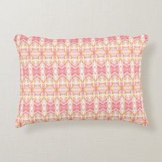 a pink and yellow pillow with an abstract design