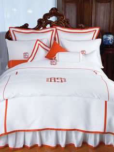 an orange and white comforter on a bed