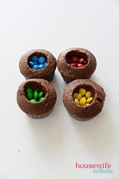 three chocolate cupcakes with candy in the middle