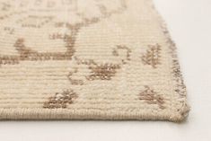 a close up of a rug on a white surface with brown and tan designs in the middle