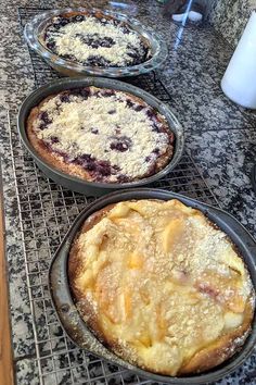 three pies sitting on top of a cooling rack next to each other in pans