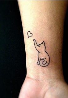 a small cat with a heart tattoo on the left side of the wrist is shown