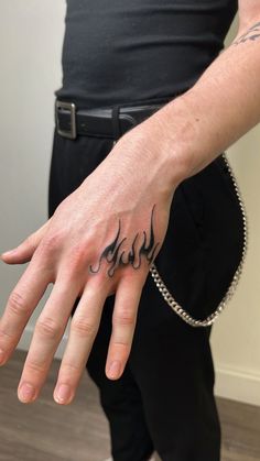 a man's hand with the word jesus tattooed on it, in black ink