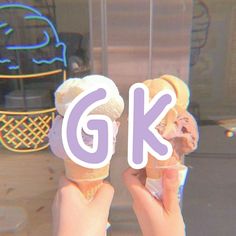 two hands holding ice cream cones with the letter g k in front of an ice cream cone