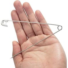 a person holding two pins in their left hand and one on top of the other