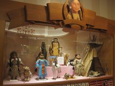 a display case filled with native american dolls