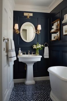 a white pedestal sink sitting under a bathroom mirror next to a bathtub and toilet