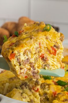 a spoon full of egg casserole being lifted from the casserole dish