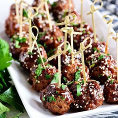 meatballs with toothpicks and garnishes on a white platter