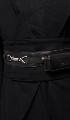 a person wearing a black belt with a metal buckle on it's side and the bottom part of their waist